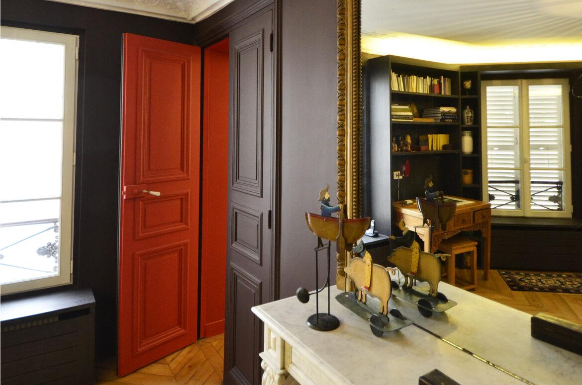 contraste des couleurs entre le sas du salon et la bibliothèque, appartement haussmannien revisité par la couleur, rouge vénitien, architecte d'intérieur paris